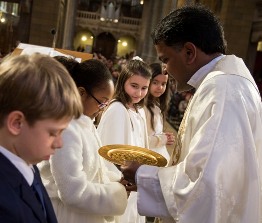 Le prêtre consacre les premier communiants 2016 à la Consolatrice des Affligés